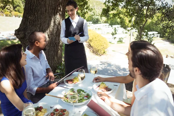 Vänner beställning till servitör — Stockfoto