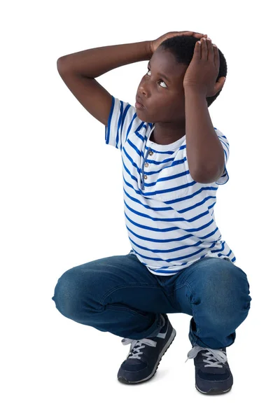 Trieste jongen crouching met hand op hoofd — Stockfoto
