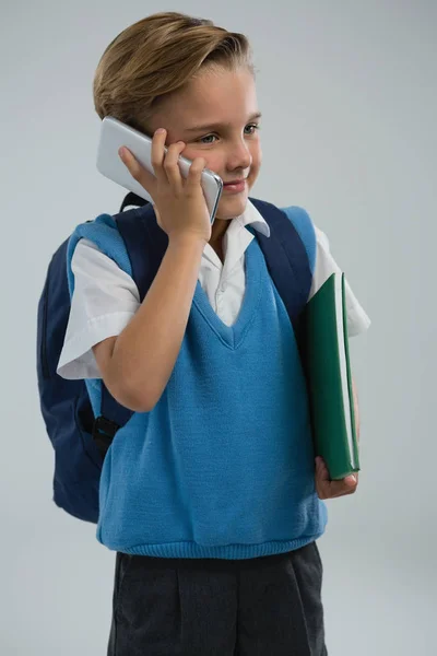 Mobil telefonda konuşurken bir okul çocuğu — Stok fotoğraf