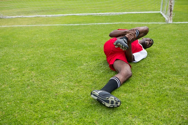 Футболист мужчина, страдающий от боли в колене — стоковое фото
