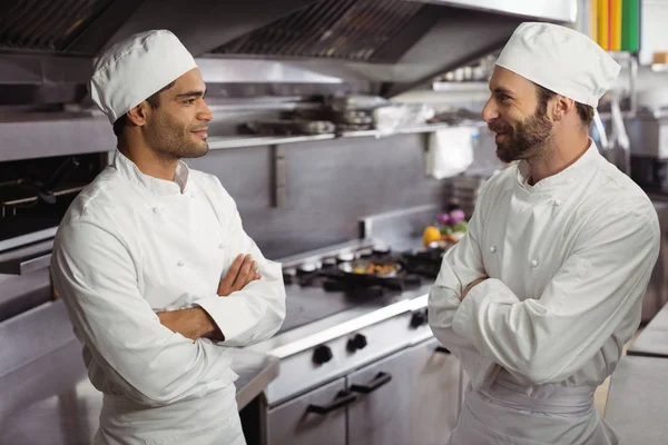 Chefs interagindo uns com os outros na cozinha — Fotografia de Stock