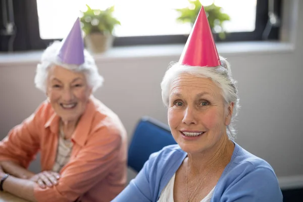 Lachende senior vrienden dragen feestmutsen — Stockfoto