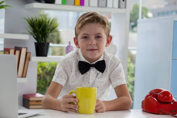 Affärsman som håller gula kaffemugg — Stockfoto