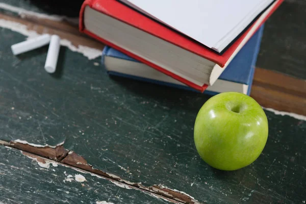 Bücher, grüner Apfel und Kreide — Stockfoto