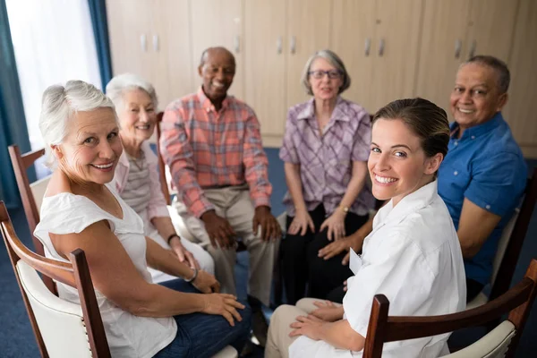 Lekarka i seniorów, siedząc na krzesłach — Zdjęcie stockowe