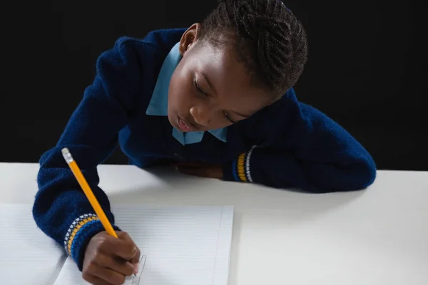 Школярка робить своє домашнє завдання — стокове фото