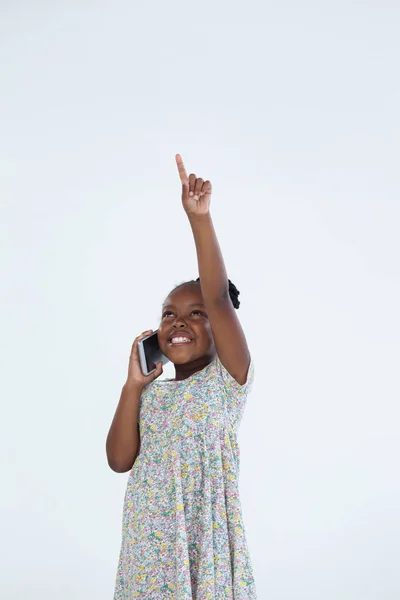Affärskvinna pekar samtidigt som talar i telefon — Stockfoto