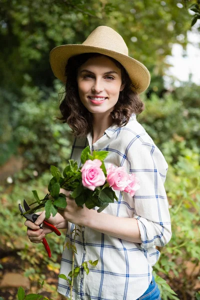 Woman trimming flowers with pruning shears — Stock Photo, Image