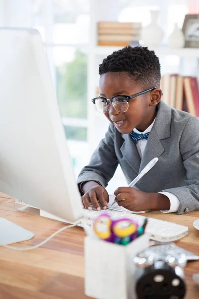 Sorrindo empresário escrever relatório enquanto olha para o computador — Fotografia de Stock