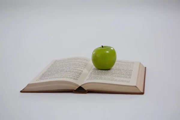 Manzana verde en libro abierto — Stockfoto