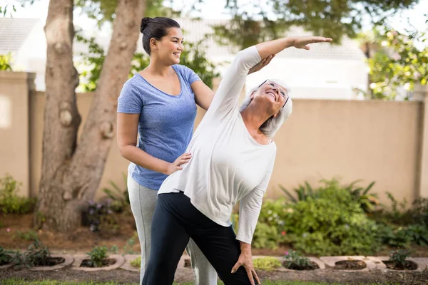 Treinador instruindo a mulher idosa durante o exercício — Fotografia de Stock
