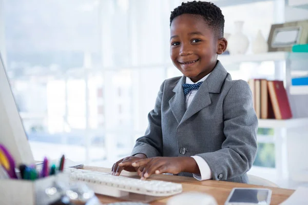 Pojke som imiterar som affärsman med hjälp av dator — Stockfoto