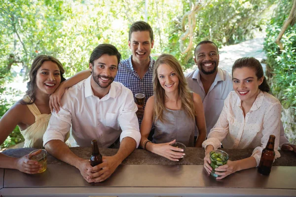 Amigos sonrientes teniendo alcohol en el mostrador —  Fotos de Stock