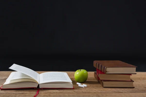 Livro aberto com maçã verde e livros — Fotografia de Stock