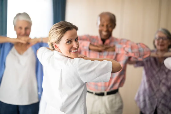 Medico donna che esercita con persone anziane — Foto Stock