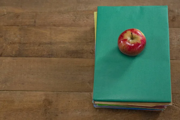 Красное яблоко в стопке книг — стоковое фото