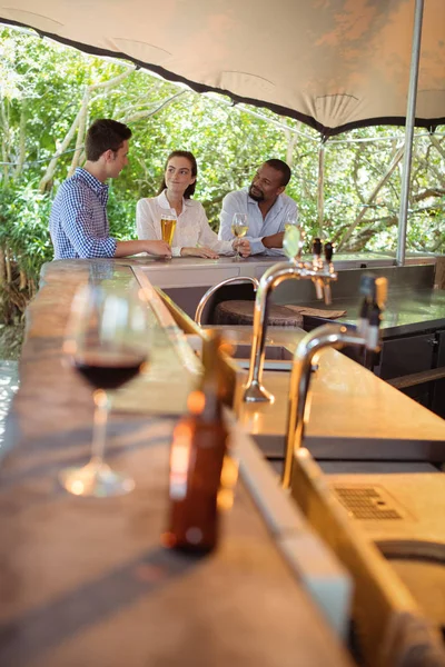 Amigos interactuando mientras toman alcohol — Foto de Stock