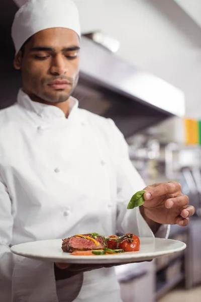 Chef segurando prato delicioso na cozinha — Fotografia de Stock