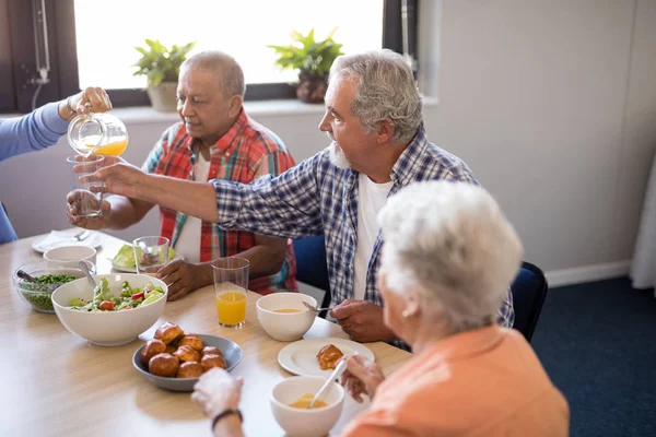 Crwoman serving juice to friends — Stock Photo, Image