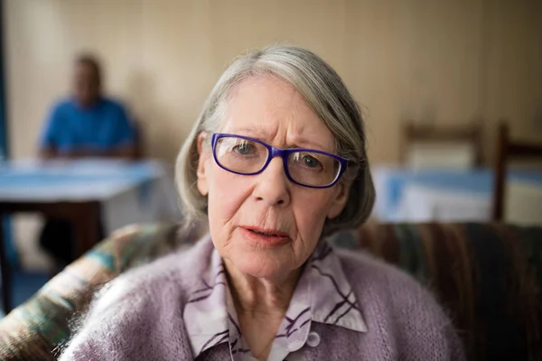 Preoccupato donna anziana seduta sulla poltrona — Foto Stock