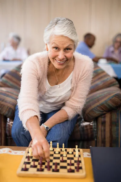 Mujer mayor confiada jugando ajedrez en la mesa — Foto de Stock