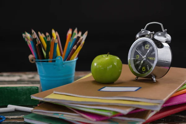 Wecker und Apfel auf Bücherstapel — Stockfoto