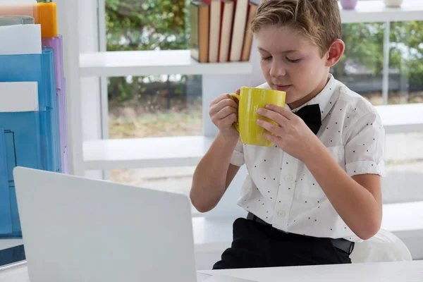 Businessman drinking coffee from yellow mug — Stock Photo, Image