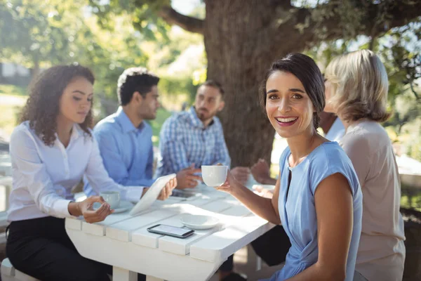 Femme assise avec des amis — Photo