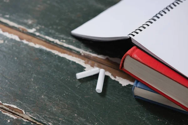 Tiza y pila de libros sobre la mesa —  Fotos de Stock