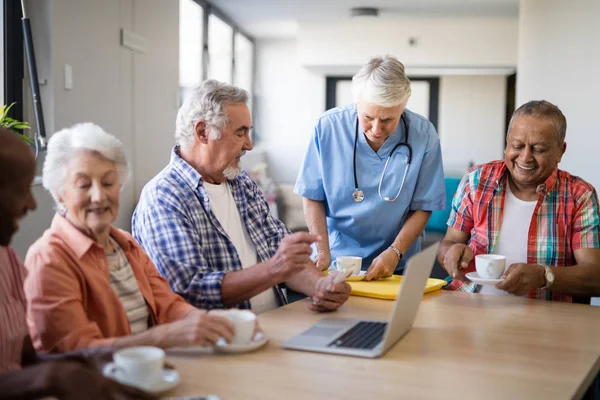 Operatore sanitario che serve caffè agli anziani — Foto Stock