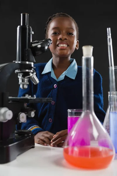 Schoolgirl using microscope — Stock Photo, Image