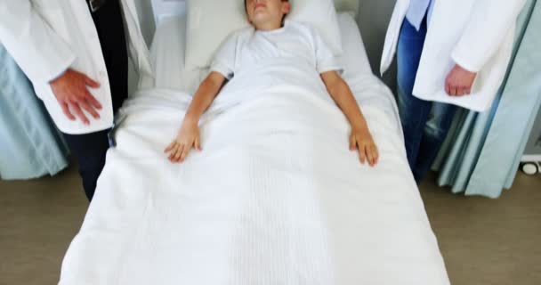 Lekarze interakcji z chłopakiem na medycznych łóżko — Wideo stockowe
