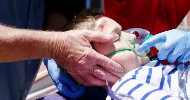 Paramedics examining injured boy — Stock Video