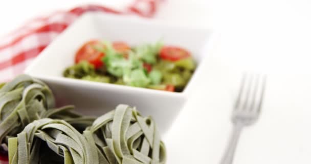 Fideos fettuccine de espinacas frescas y tazón de ensalada en la mesa — Vídeos de Stock
