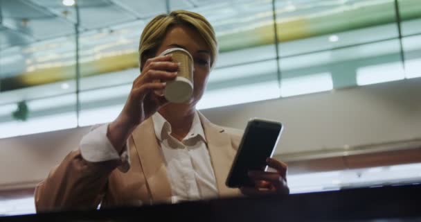 Üzletasszony, mobiltelefon tartó, és kávét iszik — Stock videók