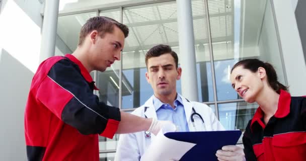 Paramédicos e médicos discutindo sobre relatório médico — Vídeo de Stock