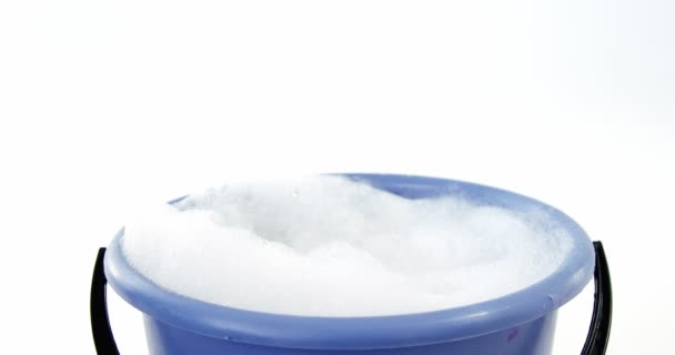 Esponja de limpieza cayendo en el cubo de jabón suds — Vídeo de stock