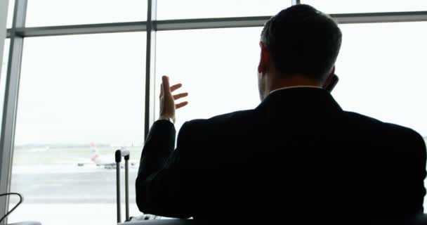 Businessman talking on mobile phone at airport — Stock Video