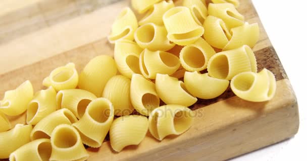 Raw pasta falling on chopping board — Stock Video