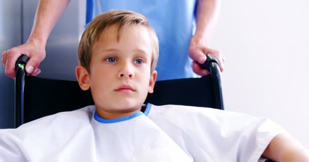 Enfermeira empurrando menino em cadeira de rodas — Vídeo de Stock