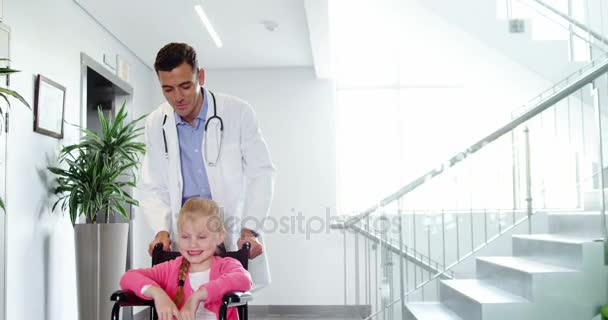 Médico empurrando menina em cadeira de rodas — Vídeo de Stock