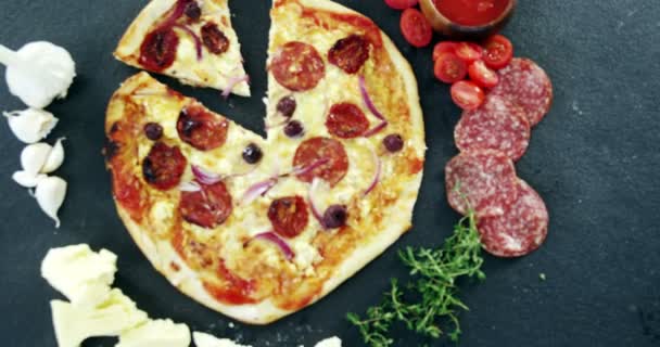Pizza sobre mesa de madera con verduras y especias — Vídeos de Stock