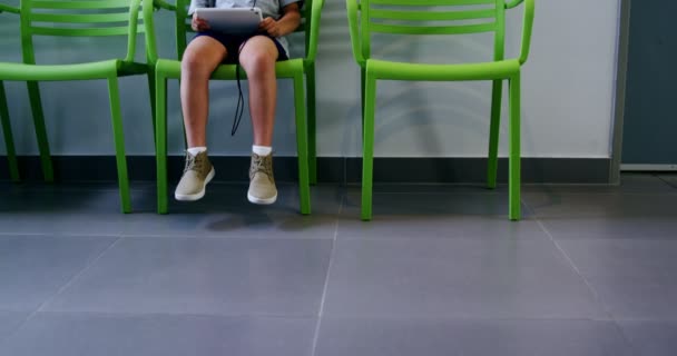 Boy pomocí digitálních tabletu v nemocniční chodbě — Stock video