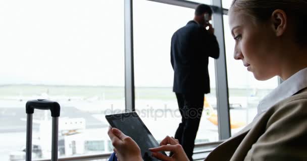 Empresária usando tablet digital e sorrindo no aeroporto — Vídeo de Stock