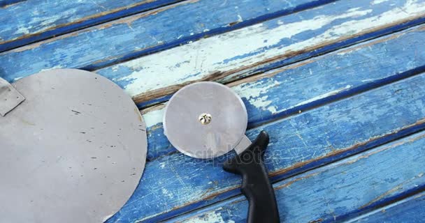 Pizza peel en cutter op houten tafel — Stockvideo