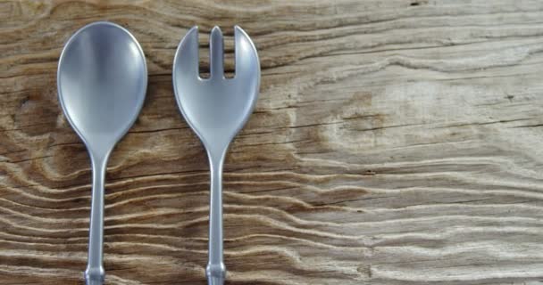 Spoon and fork on wooden table — Stock Video