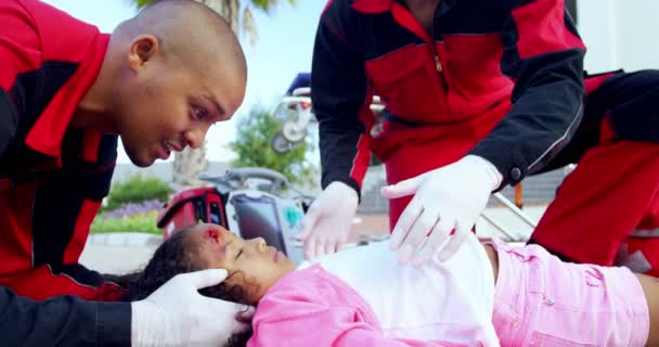 Paramédicos examinando menina ferida — Vídeo de Stock