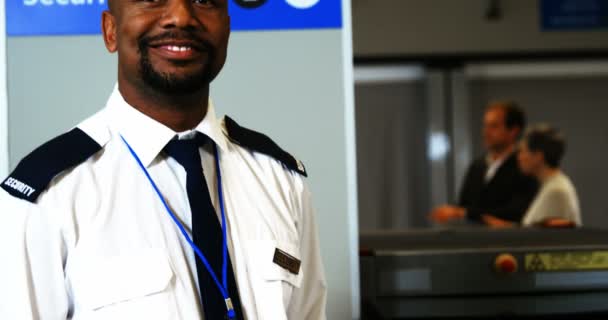 Equipe de segurança sorrindo segurando detector de metais de pé no aeroporto — Vídeo de Stock