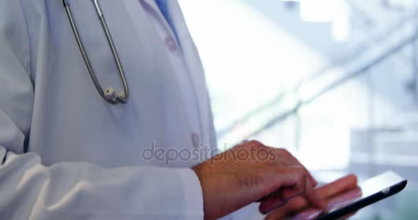 Lekarz za pomocą cyfrowego tabletu w korytarzu — Wideo stockowe