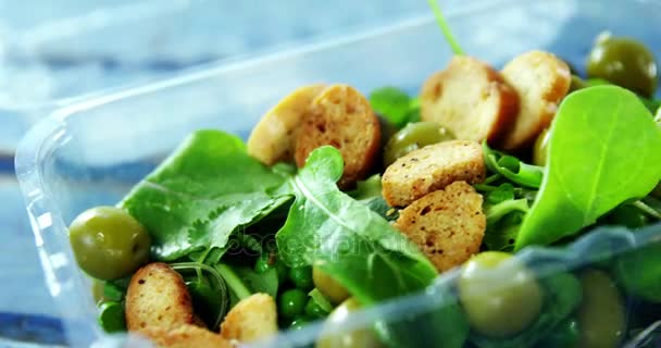 Frisse salade in kunststoffles — Stockvideo